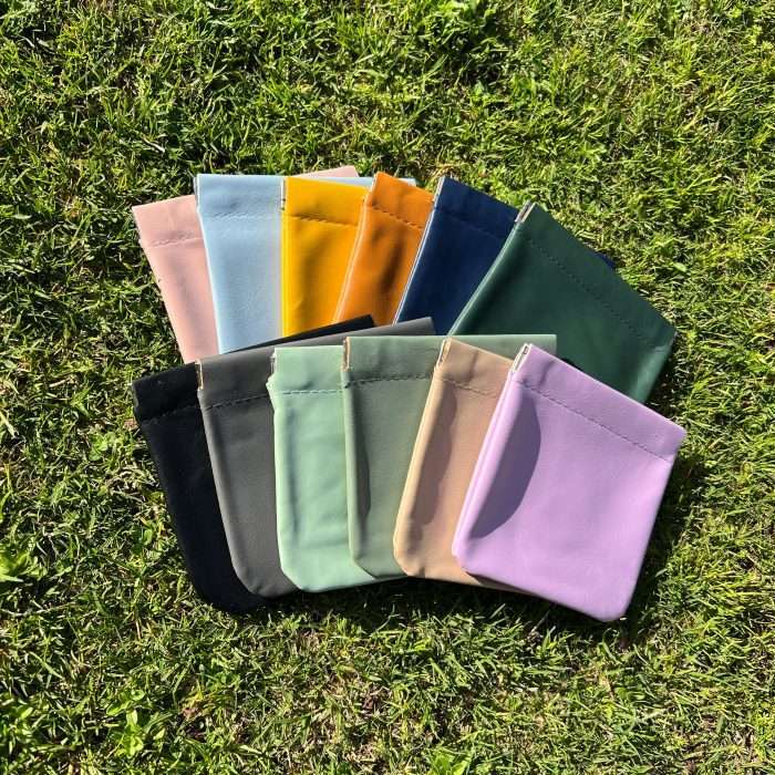 A range of colorful PU leather coin bags on grass