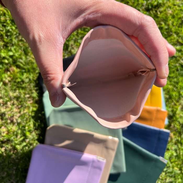 Assorted PU leather coin bags in various colors displayed outdoors